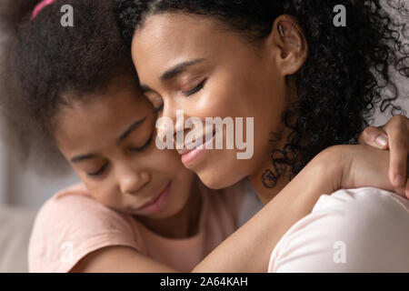 Close up di amorevole mom nero abbracciando cuddling con la figlia Foto Stock