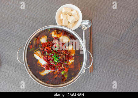 Sichuan piccante pesce bollito con red hot peperoncino piccante. Asia Cina Chongqing Chengdu cibo. Lay piatto vista dall'alto. Il cibo. Foto Stock