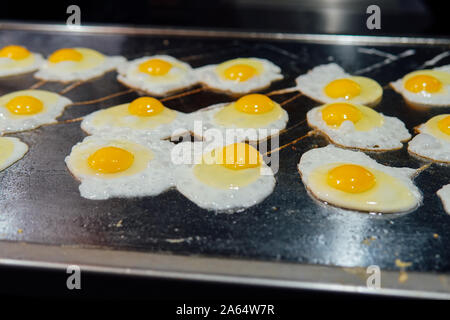 Il cuoco prepara le uova nella cucina del ristorante Foto Stock