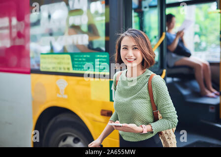 Viaggiatori femmina andando fuori il bus terminal Foto Stock