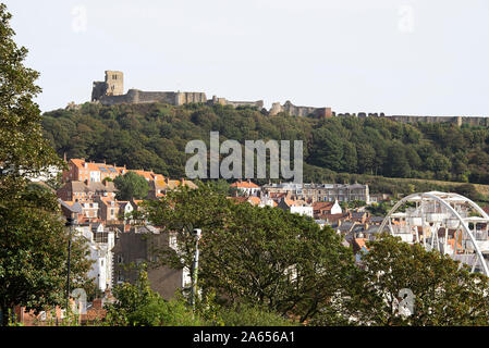 Vista del Castello di Scarborough sulla scogliera del Castello e parte della città di Seaside con Woodland e Big Wheel North Yorkshire Inghilterra Regno Unito Foto Stock