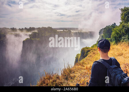 Tourist guarda al Victoria Falls sul fiume Zambesi in Zimbabwe Foto Stock