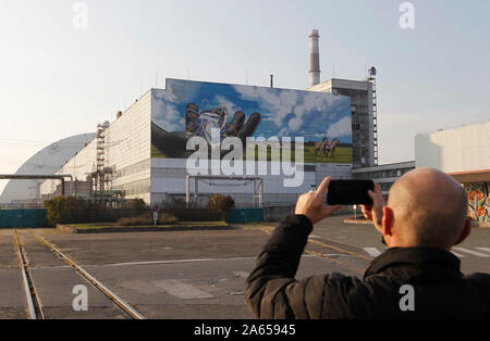 Kiev, Ucraina. 23 Ott, 2019. Un uomo prende una foto di un murale gigante chiamato 'guardando al futuro dell' autore Valerii Korshunov che è visto in un edificio di centrale nucleare di Cernobyl. Credito: SOPA Immagini limitata/Alamy Live News Foto Stock