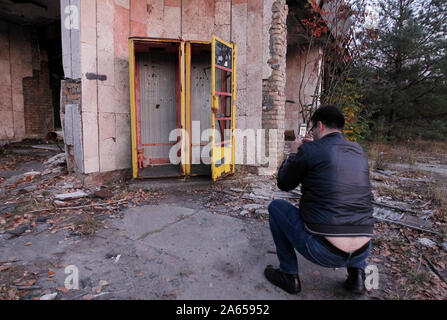 Kiev, Ucraina. 23 Ott, 2019. Un visitatore prende le foto nella città abbandonate di pripjat non lontano della centrale nucleare di Cernobyl. Credito: SOPA Immagini limitata/Alamy Live News Foto Stock