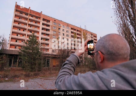 Kiev, Ucraina. 23 Ott, 2019. Un visitatore prende le foto nella città abbandonate di pripjat non lontano della centrale nucleare di Cernobyl. Credito: SOPA Immagini limitata/Alamy Live News Foto Stock