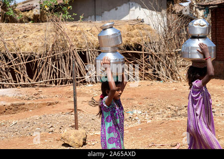 Le giovani ragazze che trasportano pentole di acqua dal bene al mal village, Thane, Maharashtra, India, Asia Foto Stock