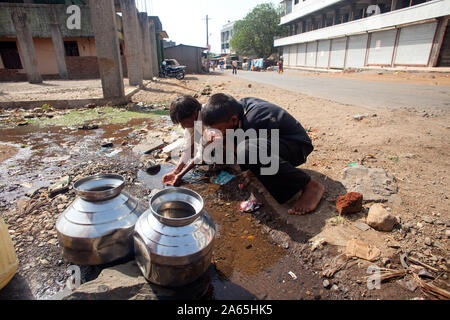 Bambini acqua potabile da Pozza, Shahapur, Mumbai, Maharashtra, India, Asia Foto Stock