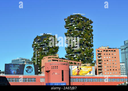 Vista panoramica sugli edifici della stazione ferroviaria di porta Garibaldi e sulle residenze del Bosco verticale del quartiere porta nuova di Milano. Giorno di cielo azzurro e soleggiato. Foto Stock