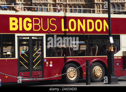 Una vista ravvicinata di un autobus aperto sul tetto su un viaggio turistico intorno a Londra passando per le Case del Parlamento, Westminster, London, con passeggeri Foto Stock