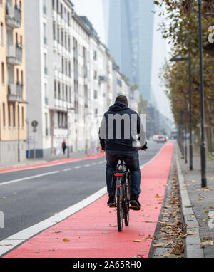 24 ottobre 2019, Assia, Frankfurt/Main: un uomo che cavalca una bicicletta su un rosso contrassegnato con pista ciclabile lungo la strada 'Schöne Aussicht'. Il consiglio della città ha deciso di rendere Francoforte una bicicletta città. Foto: Sila Stein/dpa Foto Stock