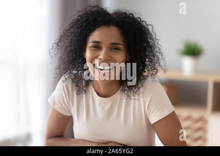 Ritratto di nero sorridente ragazza millenaria che pongono a casa Foto Stock