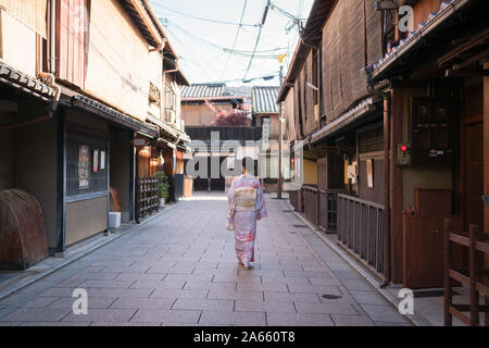 Giovane donna asiatica in kimono camminare in un vuoto di Street nel quartiere Higahiyama, Gion, Kyoto, Giappone Foto Stock
