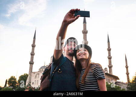 Un paio di turisti prendendo un selfie contro lo sfondo della Moschea Blu a Istanbul. Visita in Turchia e le sue attrazioni. Foto Stock