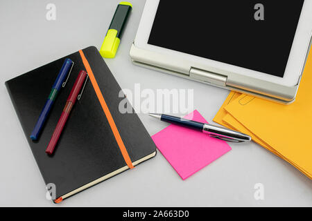 Forniture per ufficio costituito da tablet con tastiera, marcatore fluorescente, il rosso e il blu marcatori, penna moderna, blocco note appiccicose e note book Foto Stock