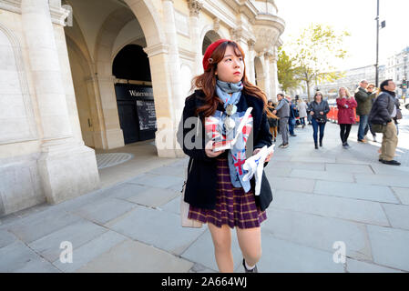 Londra, Inghilterra, Regno Unito. Femmina giovane turista giapponese in Trafalgar Square Foto Stock