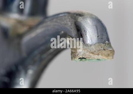 Close-up di calcare. Messa a fuoco selettiva su hard deposito di acqua sul vecchio tocca il tubo di lancio. Chrome la cucina o il bagno rubinetto con croccante di carbonat calcio Foto Stock