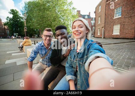 Un selfie colpo di due uomini e una donna, la donna sta prendendo il selfie. Foto Stock