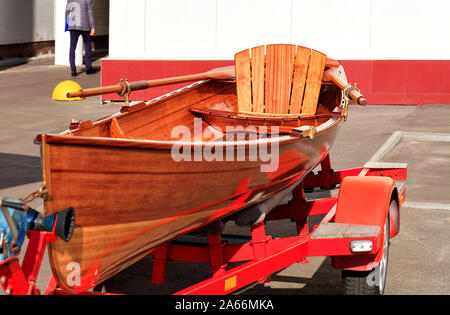 Legno, brillante arancio bella canoa parcheggiata da un giovane imprenditore di fronte ad un edificio per uffici in un parcheggio. Foto Stock