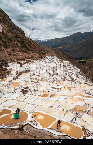 Vista in elevazione dei lavoratori a Maras salt marsh terrazze, a Salinas de Maras, regione di Cuzco, Perù Foto Stock