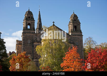 Edimburgo, Scozia, Regno Unito. Il 24 ottobre 2019. Colorato fogliame autunnale di Rowan e betulle nei giardini di Princes Street West in primo piano contro il fondale di St Cuthberts Chiesa Parrocchiale, Lothian Road. Foto Stock