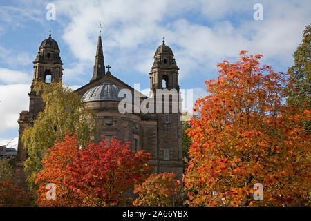 Edimburgo, Scozia, Regno Unito. Il 24 ottobre 2019. Colorato fogliame autunnale di Rowan e betulle nei giardini di Princes Street West in primo piano contro il fondale di St Cuthberts Chiesa Parrocchiale, Lothian Road. Foto Stock