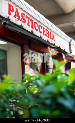 Testo pasticceria sul telo. Italiano di pasticceria. Facciata su pasticceria. Il fogliame verde nella parte anteriore del cafè e negozio di dolciumi. Foto Stock