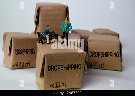 Imprenditore in miniatura a parlare su scatole con testo Dropshipping isolato bakground bianco Foto Stock