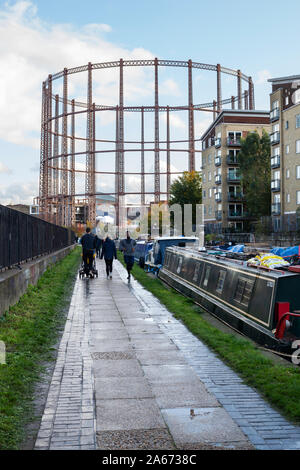 L'alzaia lungo il Regent's Canal vicino il gatto e il montone ponte con vuoto gasometro Hackney, East London, Londra, Regno Unito, Europa Foto Stock