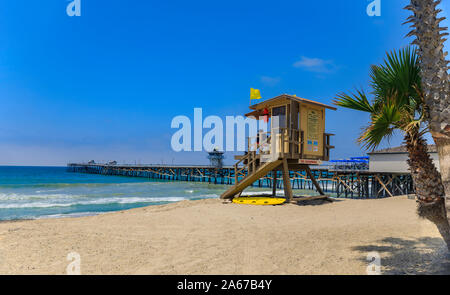 Spiaggia di San Clemente, famosa destinazione turistica in California, Stati Uniti d'America con un bagnino torre in primo piano e il molo in background Foto Stock