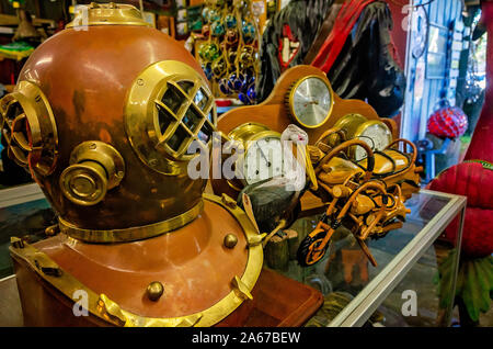 Un antico in ottone e rame casco subacquea e altri souvenir nautiche sono affollate sui ripiani, 6 ott. 2019, in Apalachicola, Florida. Foto Stock