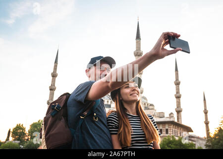 Un paio di turisti prendendo un selfie contro lo sfondo della Moschea Blu a Istanbul. Visita in Turchia e le sue attrazioni. Foto Stock