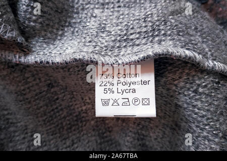 Lato errato di un abito grigio di lana, la composizione viene specificato: cotone, poliestere e lycra. Composizione per i tessuti abbigliamento etichetta sulla texture grigio b Foto Stock