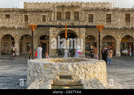 Doha,Qatar-March 30,2018: Souk Waqif marketplace in Doha vista diurna con vecchio pozzo fontana in primo piano Foto Stock