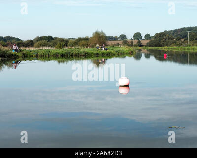 Un tranquillo di scena sul restaurato bacino del canale al mulino Ebridge su teh North Walsham e Dilham Canal in North Norfolk con pescatori sperando per una cattura. Foto Stock