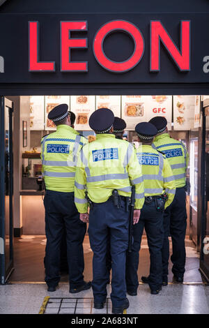 Londra, UK. La Metropolitan Police officers stand sulla coda presso un ristorante fast food Foto Stock
