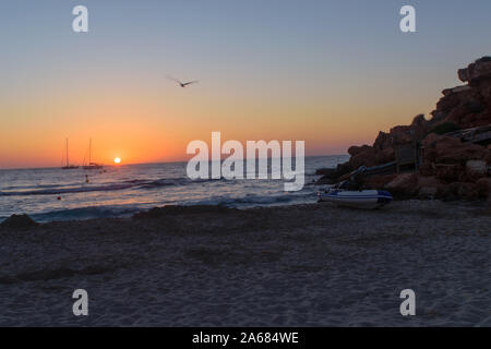 Tramonto a Cala Saona, Formentera, nella distanza Es Vedra rock è visibile Foto Stock