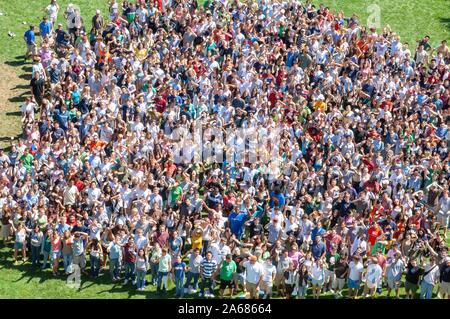 Panoramica di una folla, in piedi vicino insieme in una zona erbosa in una giornata di sole durante un collegio settimana di orientamento evento e guardando verso la telecamera, presso la Johns Hopkins University, Baltimora, Maryland, 4 settembre 2006. Dall'Homewood raccolta di fotografie. () Foto Stock