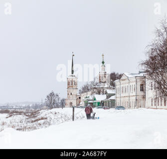 Veliky Ustyug, Russia - 5 Febbraio 2019: uomo rastrellatura neve a giornata invernale in Veliky Ustyug Foto Stock