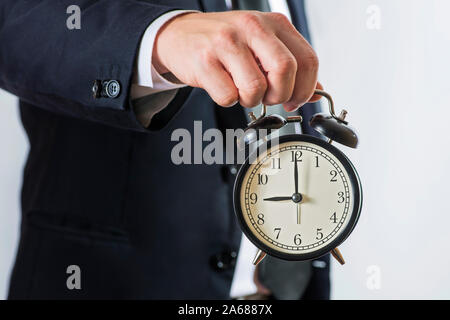 Imprenditore tenere premuto il tasto alarm clock. Tempo di business management concetto. Imprenditore con sveglia in mano. Foto Stock