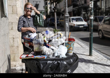 Un cestino pieno di spazzatura a parte la strada nel centro di Patrasso.comune i lavoratori di tutta la Grecia hanno lanciato una 48 ore di sciopero per protestare contro i piani del governo a portata di mano oltre ad investitori privati della parte comune dei servizi. Lo sciopero mostra già il suo primo impatto con sacchetti di rifiuti ammucchiati sulle strade. Foto Stock