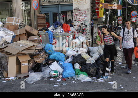 La gente a piedi passato sacchi della spazzatura accatastati a parte la strada a Patrasso.comune i lavoratori di tutta la Grecia hanno lanciato una 48 ore di sciopero per protestare contro i piani del governo a portata di mano oltre ad investitori privati della parte comune dei servizi. Lo sciopero mostra già il suo primo impatto con sacchetti di rifiuti ammucchiati sulle strade. Foto Stock