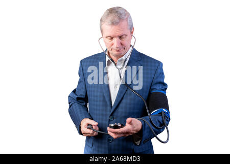 Un uomo anziano in una tuta misure di pressione, da lui stesso, con una mano tonometro. Isolato su uno sfondo bianco. Foto Stock