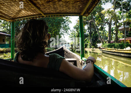 Alleppey - Alappuzha, India - 13 Novembre 2017: Turistica ragazza seduta in barca durante il tour attraverso i piccoli canali del Kerala backwaters Foto Stock