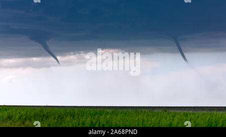 Le nubi a doppio imbuto appaiono su un campo come un paio di tornado di Landbut si sviluppano da una tempesta vicino a St. Francis, Kansas, USA Foto Stock