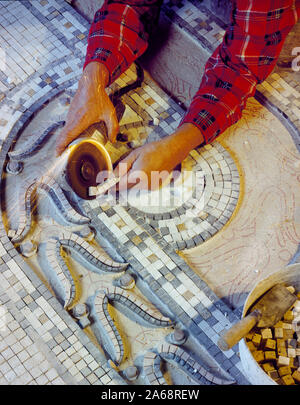 Lavorare su un pavimento a mosaico durante il restauro del Willard Hotel di Washington, D.C. Foto Stock