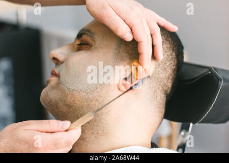 Bel ragazzo rimuovere i peli dal naso e orecchie con trimmer Foto stock -  Alamy