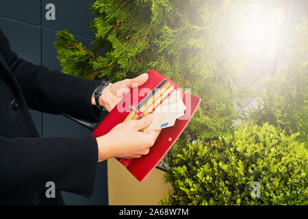 Soldi e carte di credito. Ragazza con portafoglio nelle sue mani. Foto Stock