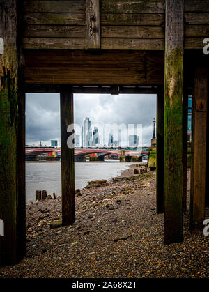 Vista da sotto il pontile Oxo Tower Wharf verso il quartiere finanziario di Londra, Regno Unito. Foto Stock