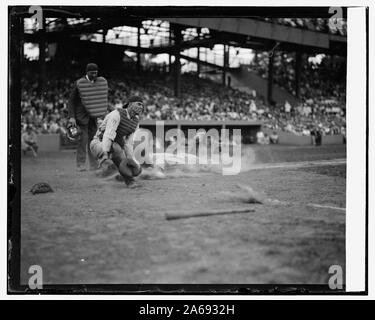 Yankees Lou Gehrig punteggi prima di testa nel quarto inning come Joe Harris' buttare fugge dall catcher Hank Severeid dei senatori. È Umpier Nallin. Battito Yanks senatori 3-2 (baseball) Foto Stock