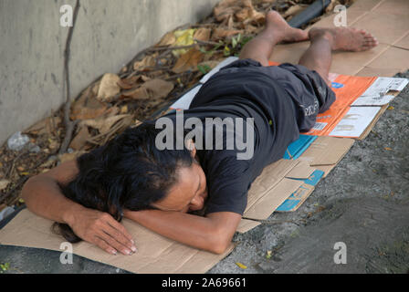 Uomo dorme sul marciapiede, Manila, Filippine. Foto Stock